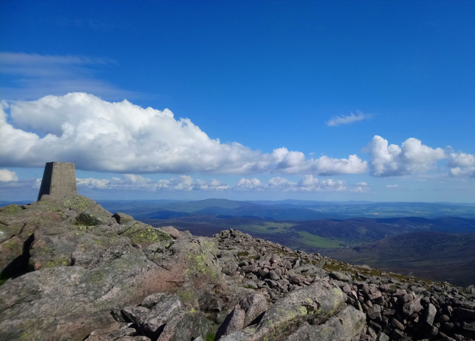 A picture of the Scottish highlands with a visible trig point