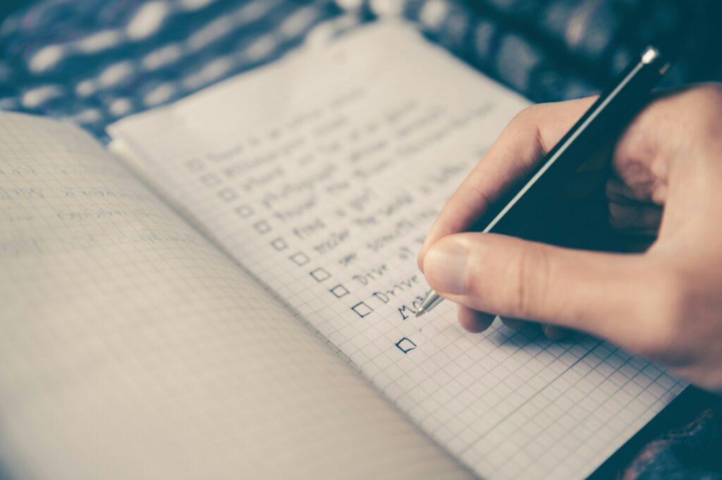 Image of a person writing gibberish in a notebook from Glenn Carstens-Peters via Unsplash